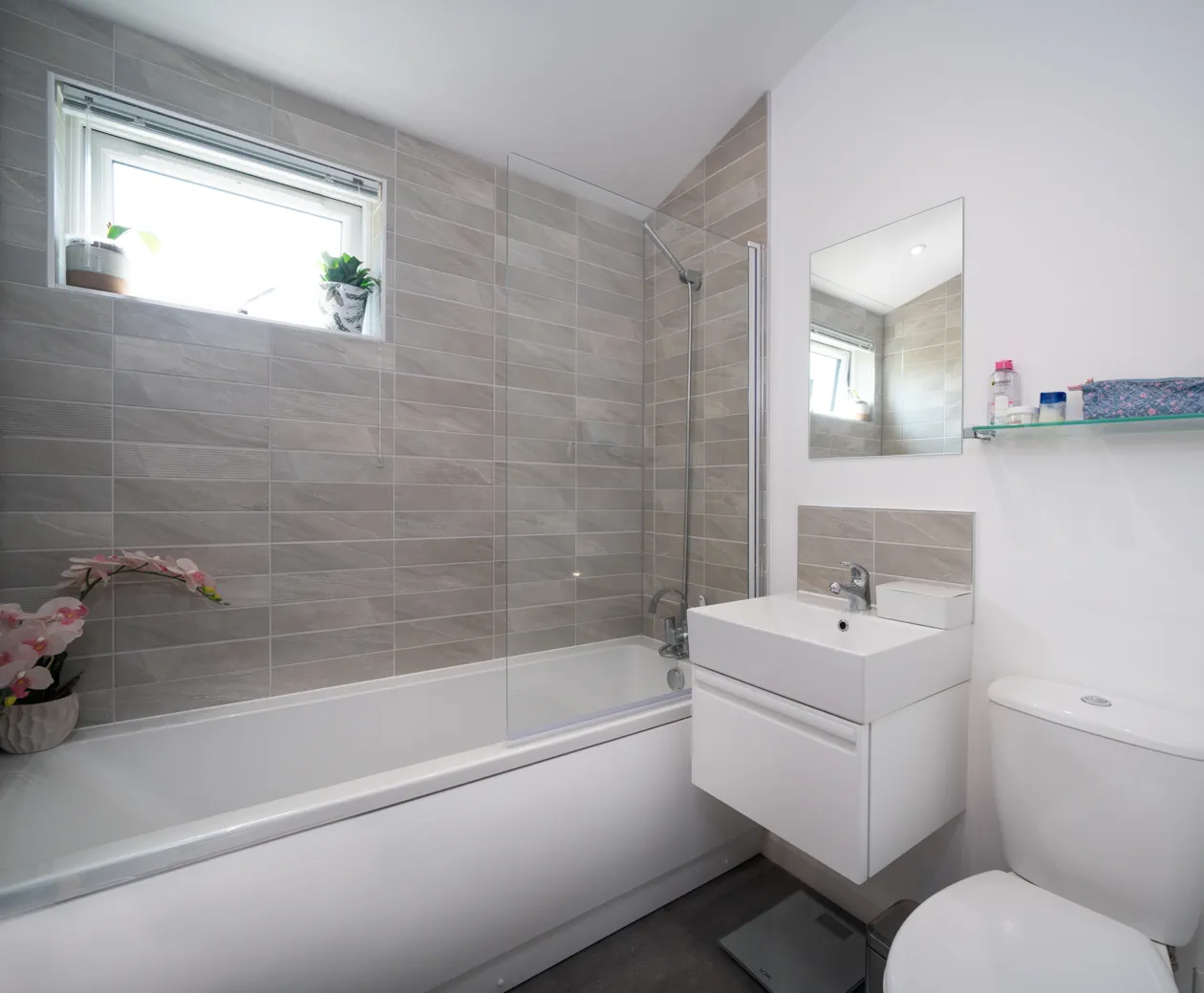 Bright and inviting bedroom with a double bed, patterned blinds, soft lighting, and large windows offering natural views — a cosy retreat for restful stays.