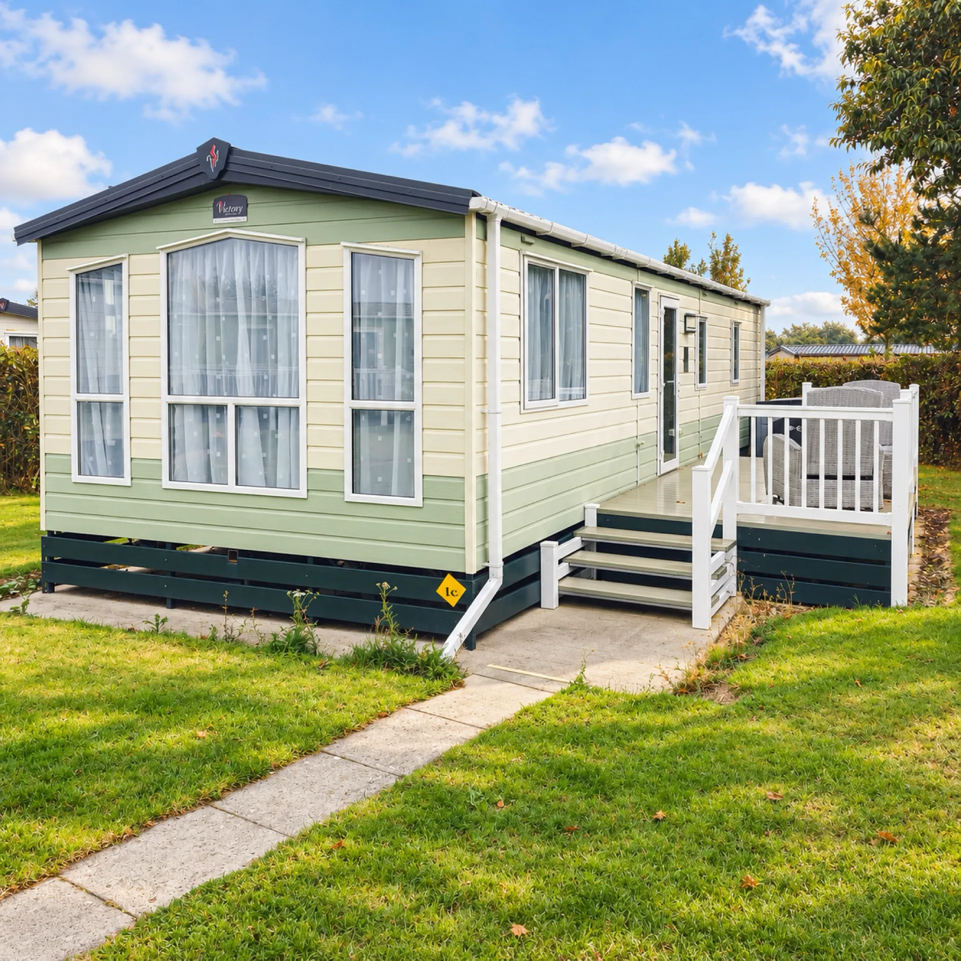 Cream and sage green Victory Torino at Pine Grove 18 with steps up to its decking, Oakdown Holiday Park